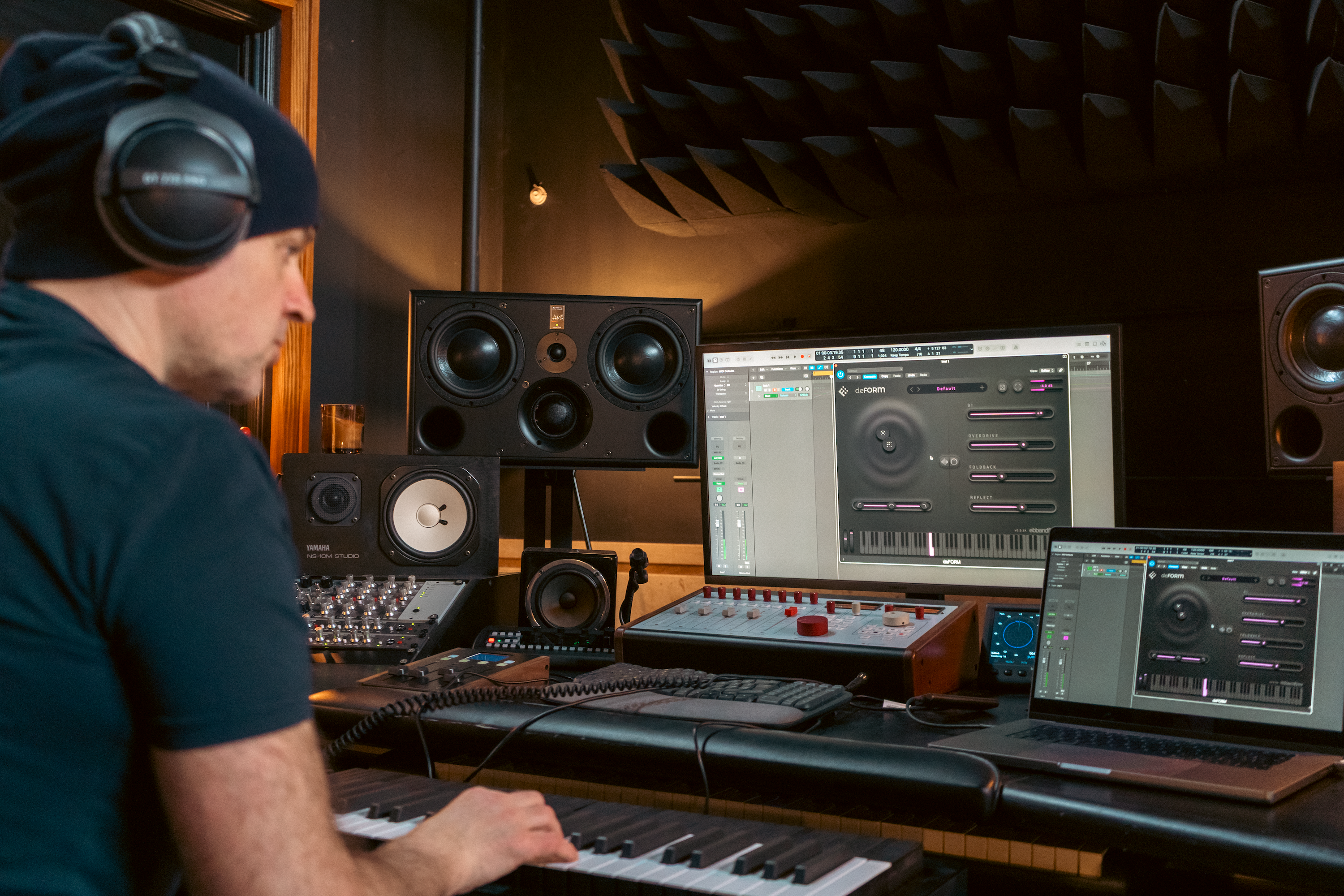 Person in a home studio setting with music production equipment.